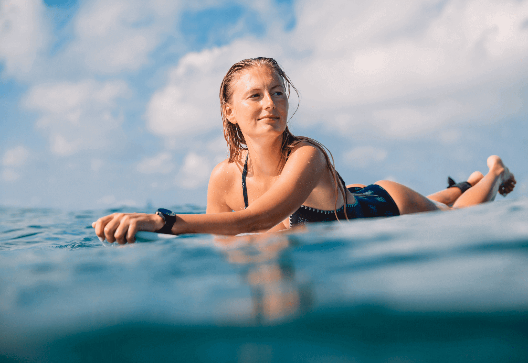 Surfer enjoying an active lifestyle, sharing a customer review about Fuelly protein coffee saving time with coffee and protein in one cup